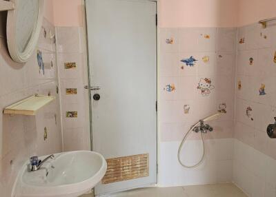 Bathroom with sink, door, and wall decorations