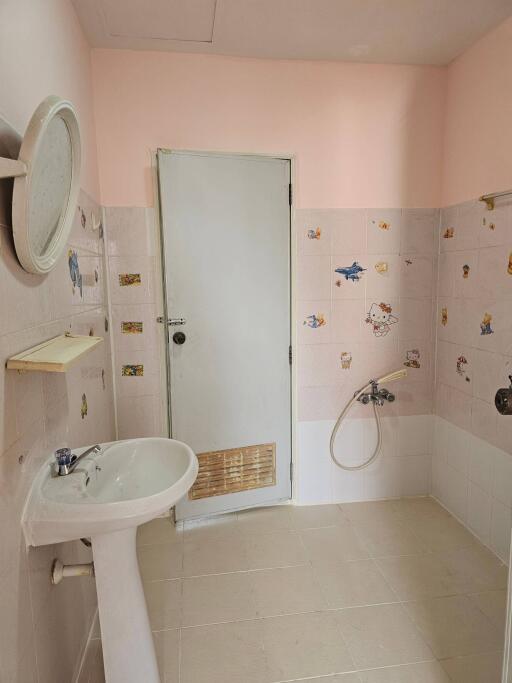 Bathroom with sink, door, and wall decorations