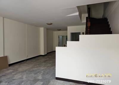 Empty living room with staircase and tile flooring