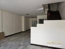 Empty living room with staircase and tile flooring