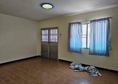 Empty bedroom with tiled floor and window with curtains