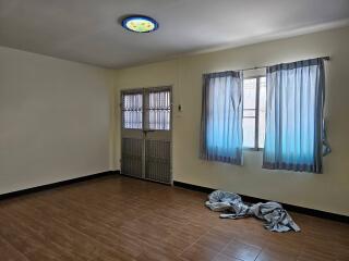 Empty bedroom with tiled floor and window with curtains