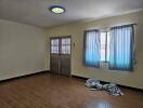 Empty bedroom with tiled floor and window with curtains