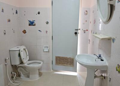 Bathroom with toilet, sink, and decorated tiles