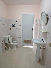 Bathroom with toilet, sink, and decorated tiles