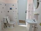 Bathroom with toilet, sink, and decorated tiles