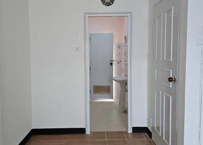 A view showing a doorway leading to a bathroom with a light neutral color scheme