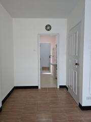 A view showing a doorway leading to a bathroom with a light neutral color scheme