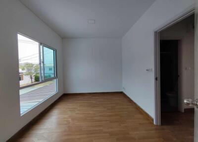 Empty bedroom with wooden floor and large window