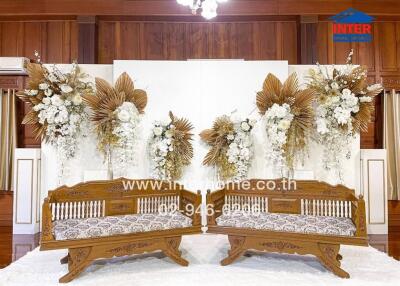 Decoratively arranged living room with wooden furniture and floral backdrop