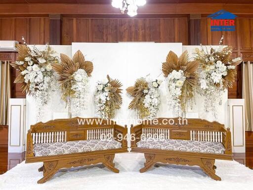 Decoratively arranged living room with wooden furniture and floral backdrop