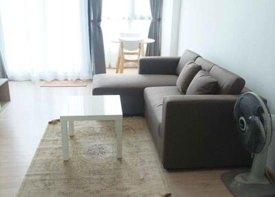 Modern living room with sofa, coffee table, and large windows