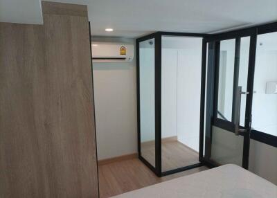 Compact bedroom with sliding glass doors and air conditioning