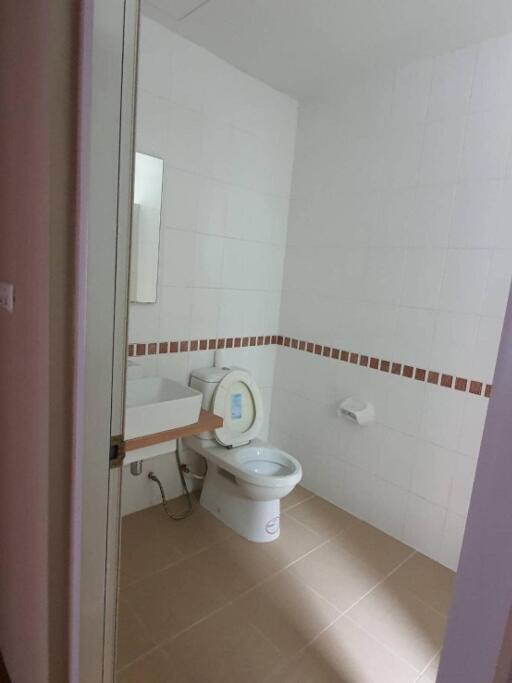 Modern bathroom with sink, toilet, and wall tiles