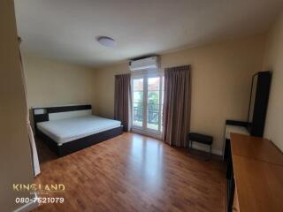 Spacious bedroom with wooden flooring and balcony access