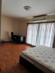 Bedroom with bed, desk, and large windows