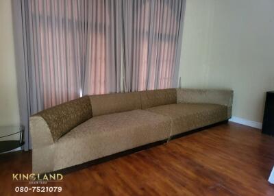 Living room with a large sectional sofa and hardwood floor