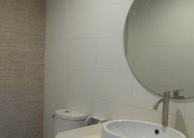 Modern bathroom with round mirror and white basin