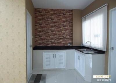 Modern kitchen with brick accent wall and white cabinets