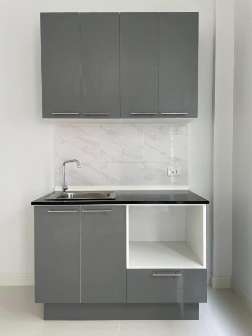 Modern kitchenette with sleek grey cabinets and a sink