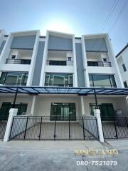 Modern three-story townhouse exterior with balconies and carport