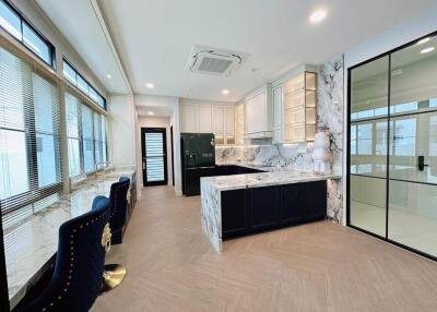 Modern kitchen with marble countertops and large windows