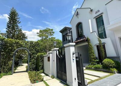 Modern two-story house with landscaped garden and gated entry