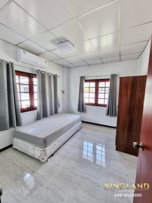 Bedroom with single bed and large windows