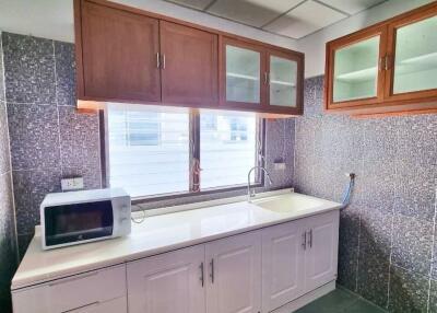 Modern kitchen with upper and lower cabinets, a microwave, and a clean countertop