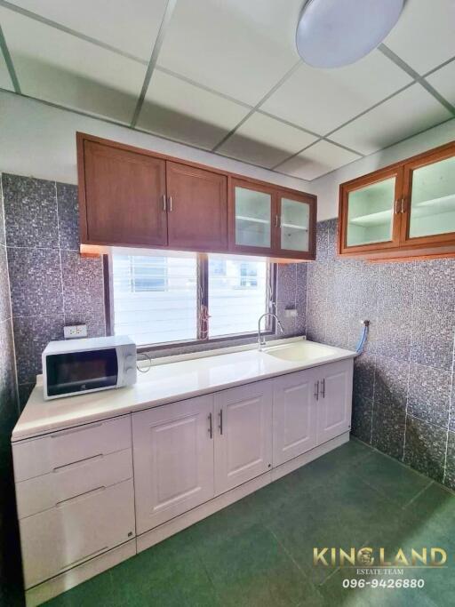 Modern kitchen with upper and lower cabinets, a microwave, and a clean countertop