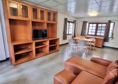 Spacious living room with wooden furniture and tiled flooring