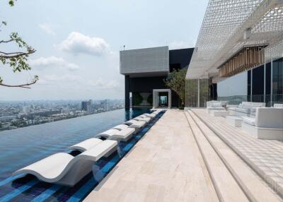 Rooftop pool with lounge chairs and panoramic city views