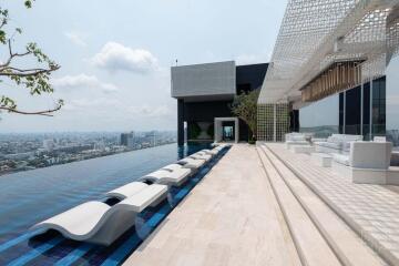 Rooftop pool with lounge chairs and panoramic city views