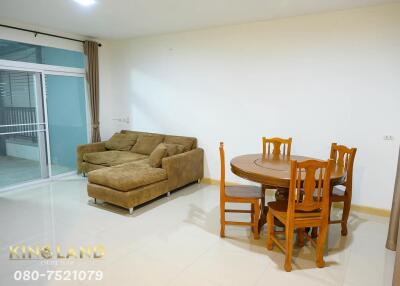 Living room with brown sectional sofa and dining table set