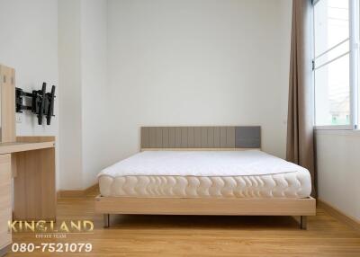 Modern bedroom with a double bed, window, dresser, and mounted TV stand