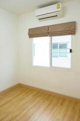 Bedroom with hardwood floors, a window, air conditioning, and blinds.