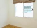 Bedroom with hardwood floors, a window, air conditioning, and blinds.