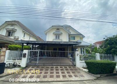 Exterior view of a two-story house with a gated driveway