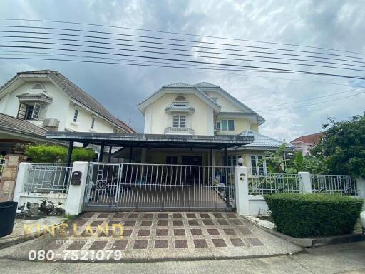 Exterior view of a two-story house with a gated driveway