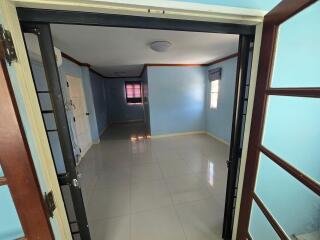 spacious, unfurnished bedroom with blue walls and tiled floor