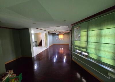 Spacious living room with dark wooden flooring, green blinds, and good natural lighting