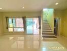 Spacious main living area with staircase and large glass doors