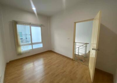 Empty bedroom with wooden floor and open door