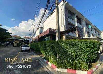 Exterior view of modern multi-story building with adjacent greenery and street