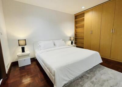 Spacious bedroom with hardwood floor and modern furnishings