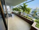 Spacious balcony with seating area and potted plants offering city views