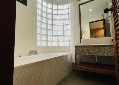 Modern bathroom with bathtub and glass block window