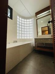 Modern bathroom with bathtub and glass block window