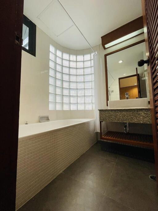 Modern bathroom with bathtub and glass block window