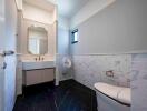 Modern bathroom with black floor tiles, a large mirror, and a spacious sink